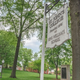 A sign bearing St John's College's name hangs next to a tree on the school's campus